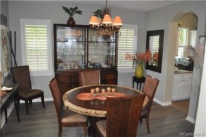 Formal dining room with beautiful plantation and entrance to butler’s pantry, also features grey pergo flooring.
